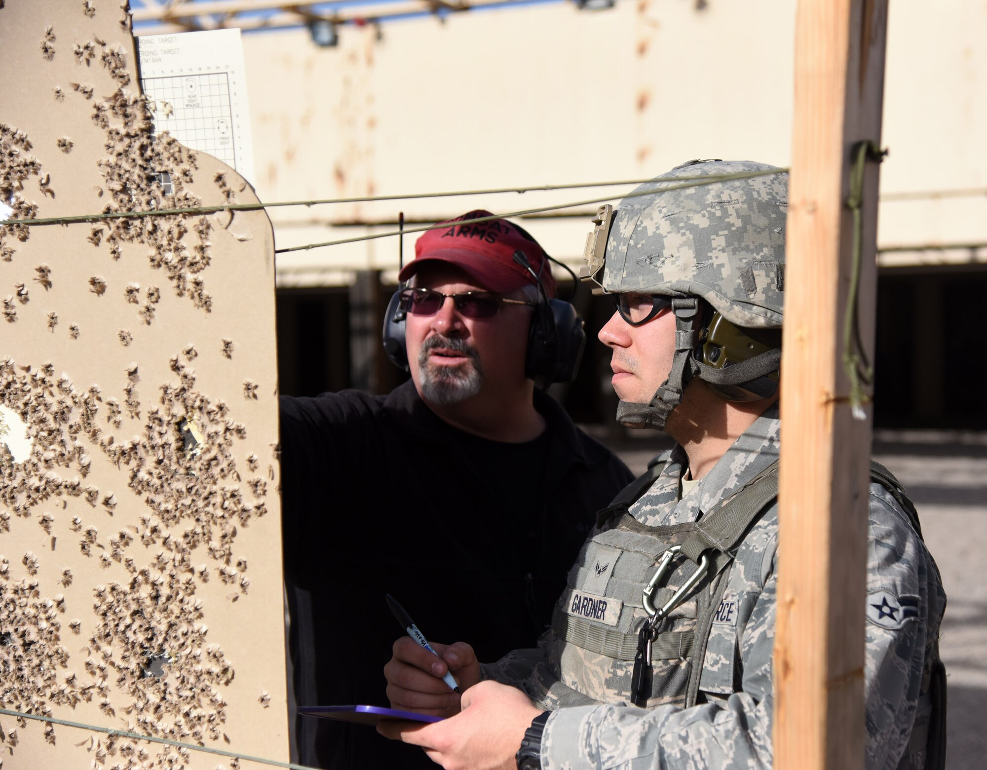 Paul Haas, 341st Security Support Squadron Combat Arms instructor, reviews Airman First Class Ryan Gardner’s target during his annual qualification training at the Combat Arms Training and Maintenance shooting range Oct. 30. Through hard work, the Airmen and instructors work together to provide a fighting force skilled and ready to face anything.  (U.S. Air Force photo/ Airman 1st Class Joshua Smoot)
