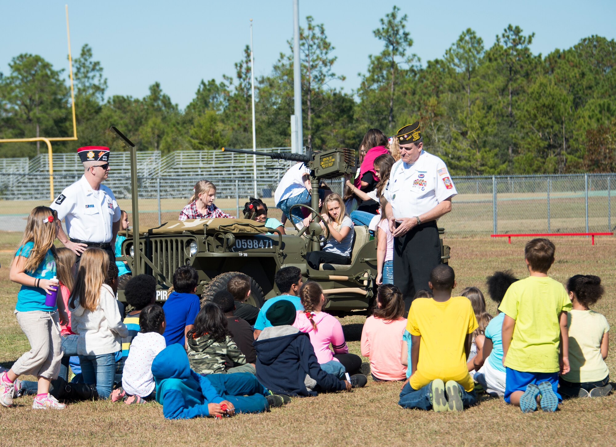 Veterans talk to children from Riverside Elementary about a World War II jeep during a Veteran’s Day celebration held at the school in Crestview, Fla., Nov. 10.  Local veterans, Airmen from explosive ordnance disposal, life support, honor guard and 6th RTB Soldiers were on hand to interact with the children in this first-ever school event.  (U.S. Air Force photo/Tech. Sgt. Jasmin Taylor)