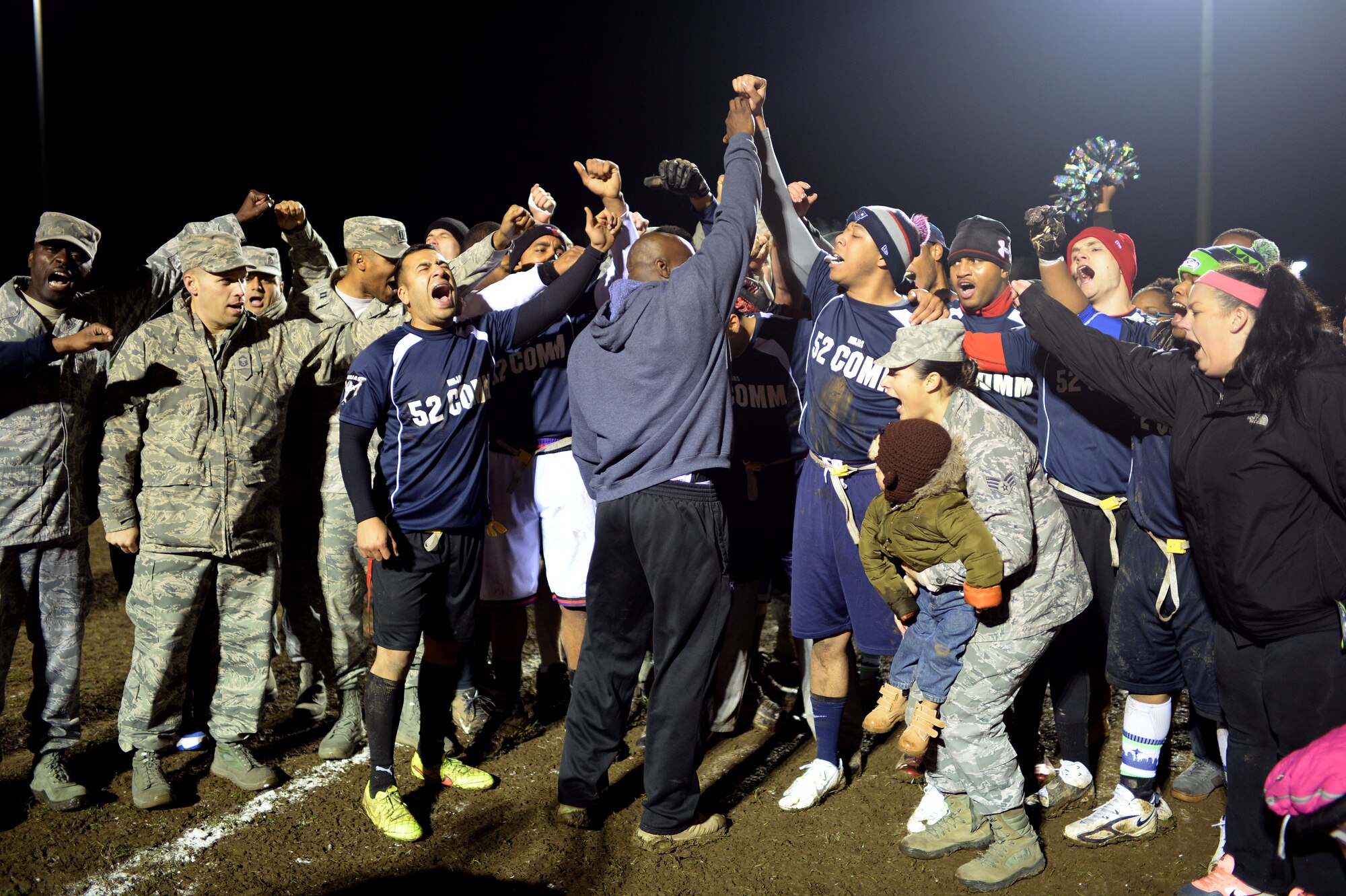 Airmen from the 52nd Communications Squadron football team celebrate their team victory during the intramural football game at Spangdahlem Air Base, Germany, Nov. 10, 2014. The 52nd CS brought home the championship trophy as well as individual awards for outstanding team performance. (U.S. Air Force photo by Staff Sgt. Daryl Knee/Released)