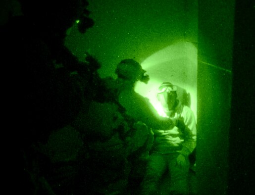 U.S. Air Force Air Commandos, along with host nation partners, search a simulated hostile force Nov. 6, 2014, during a training mission at RAF Sculthorpe in Norwich, England. During the mission, Air Commandos searched for simulated potential threats and rescued simulated hostages in the training area while using night vision googles. (U.S. Air Force photo by Airman 1st Class Dillon Johnston/Released)