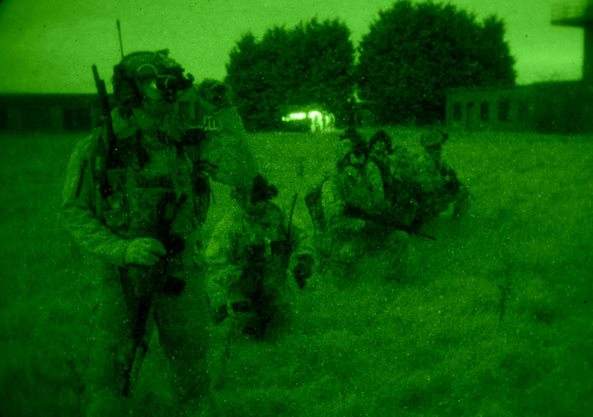 U.S. Air Force Air Commandos, along with host nation partners, use night vision goggles to survey an area Nov. 6, 2014, during a training mission at RAF Sculthorpe in Norwich, England. During the training mission, Air Commandos searched for simulated potential threats and rescued simulated hostages in the training area. (U.S. Air Force photo by Airman 1st Class Dillon Johnston/Released)