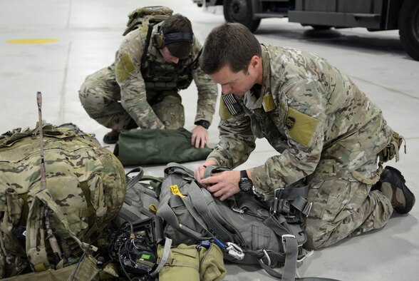 Air Commandos from the 321st Special Tactics Squadron prepare their parachute rigs prior to a mission which required them to jump from an MC-130J Commando II belonging to the 67th Special Operations Squadron Nov. 6, 2014, during a training mission at RAF Sculthorpe in Norwich, England. During the training mission, Air Commandos searched for simulated potential threats and rescued simulated hostages in the training area. (U.S. Air Force photo by Airman 1st Class Dillon Johnston/Released)