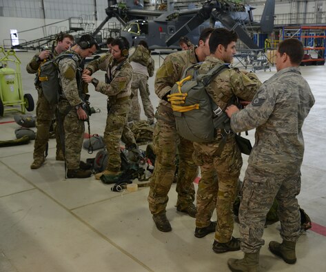 Air Commandos from the 321st Special Tactics Squadron don their parachute rigs prior to a mission which required them to jump from an MC-130J Commando II belonging to the 67th Special Operations Squadron Nov. 5, 2014, during a training mission at RAF Sculthorpe in Norwich, England. During the training mission, Air Commandos searched for simulated potential threats and rescued simulated hostages in the training area. (U.S. Air Force photo by Tech. Sgt. Stacia Zachary/Released)