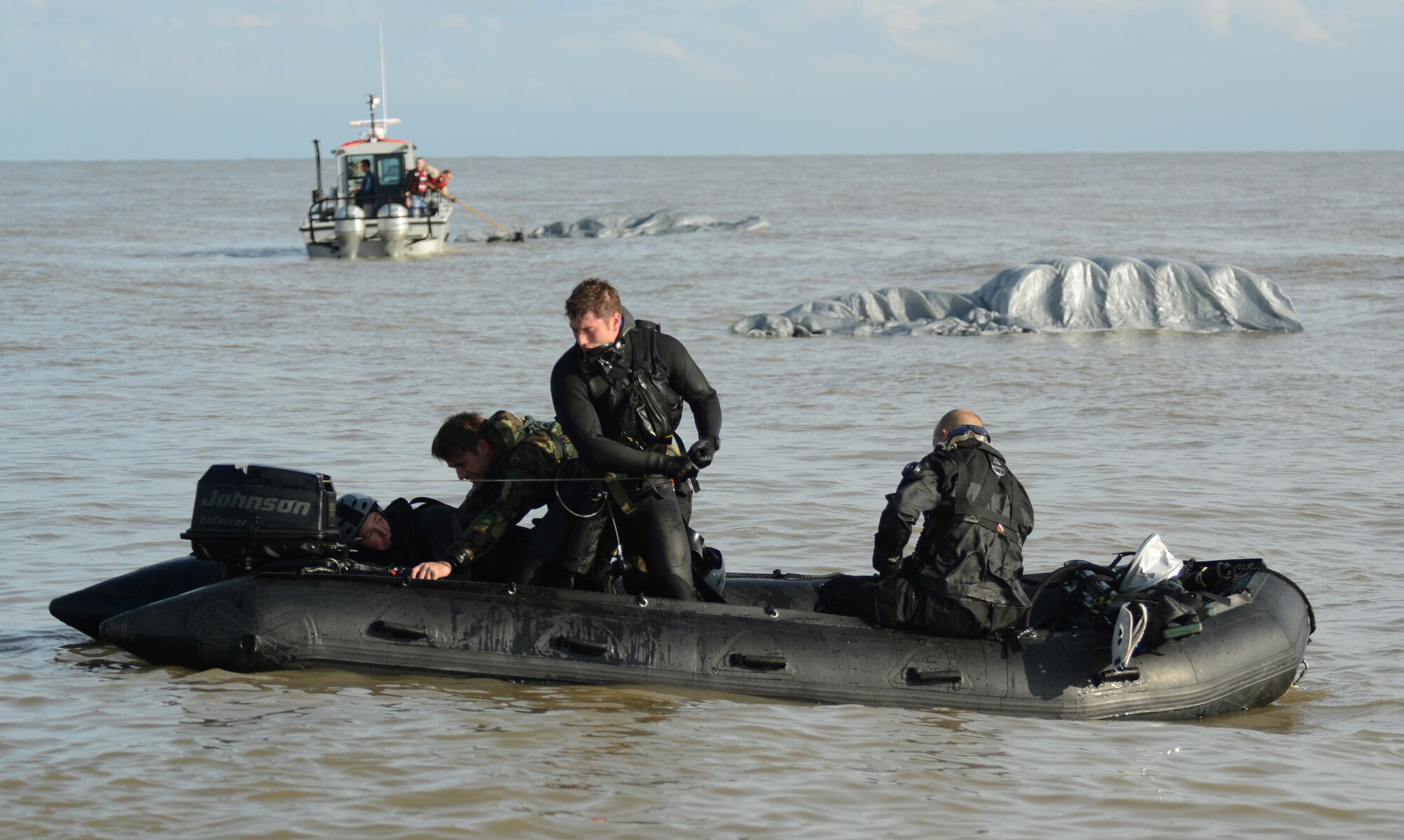 Air Commandos from the 321st Special Tactics Squadron, RAF Mildenhall, and the 56th Rescue Squadron, RAF Lakenheath, load a zodiac boat with other gear that was dropped from the MC-130J Commando II into the water off the coastline of Ipswich, England, Nov. 4, 2014. The Air Commandos conducted amphibious special operations procedures throughout the week. (U.S. Air Force photo by Airman 1st Class Dillon Johnston/Released)