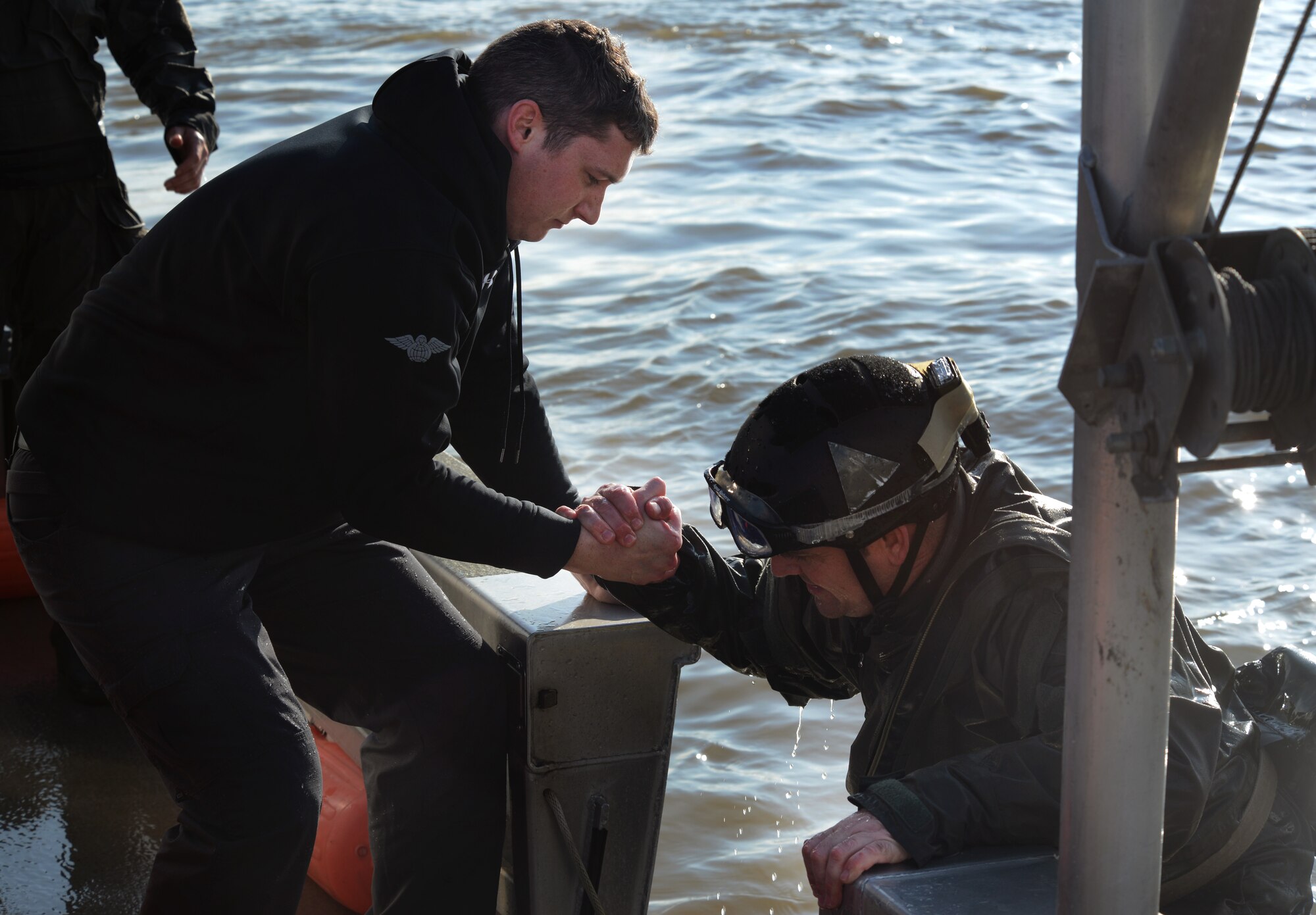 An Air Commando helps his comrade into the Boston Whaler Guardian watercraft after and air-water jump off the coastline of Ipswhich, England, Nov. 4, 2014. Air Commandos from the 321st Special Tactics Squadron, RAF Mildenhall, and the 56th Rescue Squadron, RAF Lakenheath, conducted amphibious special operations procedures throughout the week. (U.S. Air Force photo by Airman 1st Class Dillon Johnston/Released)