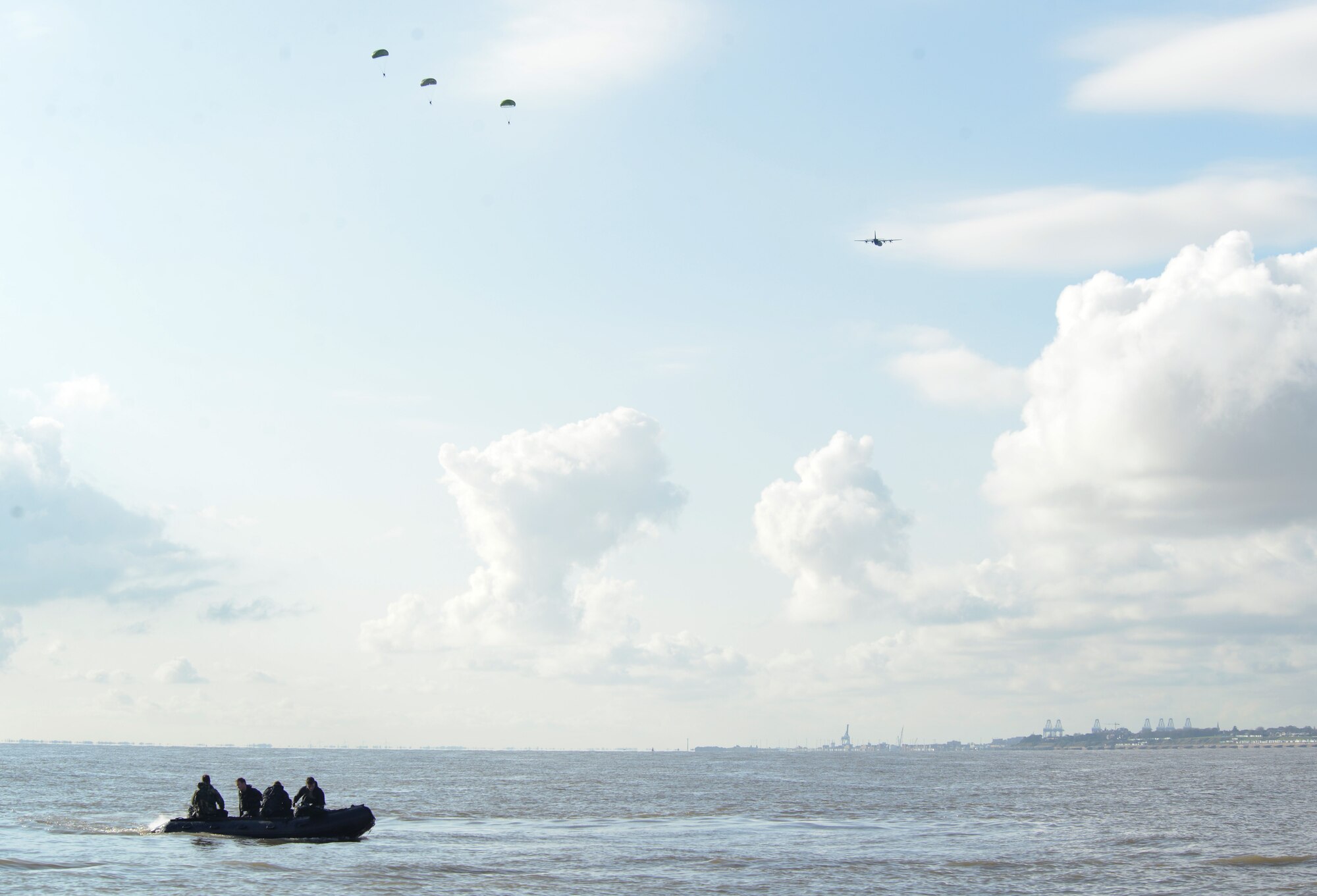 As an MC-130J Commando II from the 67th Special Operations Squadron passes over the water drop zone, Air Commandos from the 321st Special Tactics Squadron, RAF Mildenhall, and the 56th Rescue Squadron, RAF Lakenheath, drop into the water off the coastline of Ipswich, England, Nov. 4, 2014. After they land and doff their parachutes, they will rendezvous with the other Air Commandos and conduct amphibious special operations procedures.. (U.S. Air Force photo by Airman 1st Class Dillon Johnston/Released)