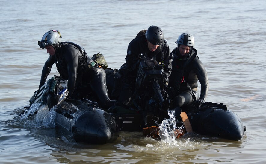 Air Commandos from the 321st Special Tactics Squadron, RAF Mildenhall, and the 56th Rescue Squadron, RAF Lakenheath, load a zodiac boat with other gear that was dropped from the MC-130J Commando II into the water off the coastline of Ipswich, England, Nov. 4, 2014. The Air Commandos conducted amphibious special operations procedures throughout the week. (U.S. Air Force photo by Airman 1st Class Dillon Johnston/Released)