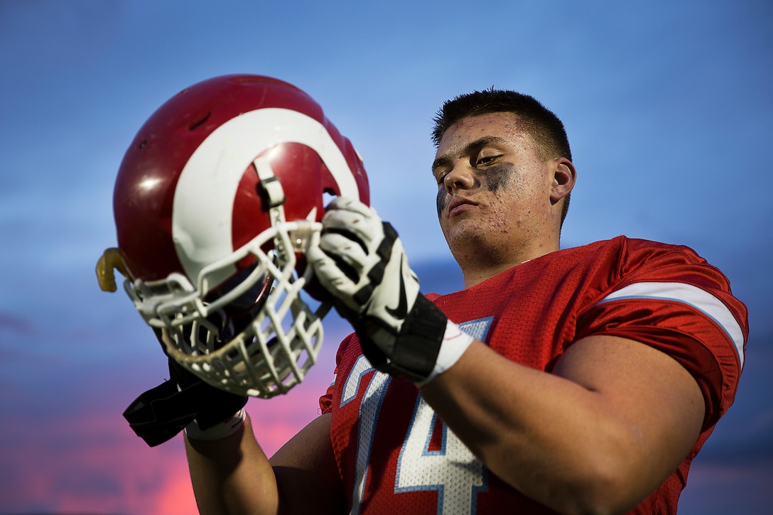 Shane Lemieux, a offensive tackle for the West Valley High School Rams varsity football team and 17-year-old native of Yakima, Wash., dons his helmet before a game against the Wenatchee High School Panthers at West Valley High School in Yakima, Wash., Oct. 31, 2014. Seattle and Yakima-based Marines presented Lemieux his 2015 Semper Fidelis All-American Bowl jersey at the game. Lemieux, a University of Oregon commit, is among approximately 100 student athletes from across the nation selected to participate in the game at the StubHub Center in Carson, Calif., Jan. 4, 2015. He joins Marysville-Pilchuck High School standout Austin Joyner as the only 2015 selectees from Washington State. (U.S. Marine Corps photo by Sgt. Reece Lodder)