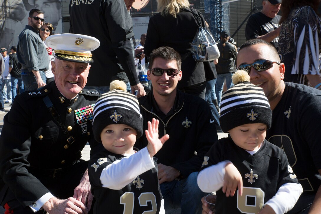 Lt. Gen. Richard P. Mills, commander of Marine Forces Reserve, poses for a photo with former Marines and their children during the Veteran Salute day presentation at Champion Square in New Orleans, Nov. 9, 2014. Veteran Salute day is part of the National Football League’s annual Salute to Service campaign in which, throughout the month, teams designate one home game to honor the military. 
