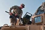 Spc. Timothy West, a driver with Troop C, 1st Squadron, 98th Cavalry Regiment of the Mississippi National Guard, attaches the barrel on a Browning .50-caliber machine gun to an MRAP gun turret prior to a convoy mission in northern Iraq on Feb. 20, 2010.