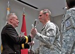 Maj. Gen. Raymond Carpenter, acting director of the Army National Guard, hands a saber over to Chief Warrant Officer 5 Gary Nisker during a change of responsibility ceremony at the Army Guard Readiness Center in Arlington, Va., Feb. 25, 2010. Nisker took the position of Command Chief Warrant Officer of the Army Guard.