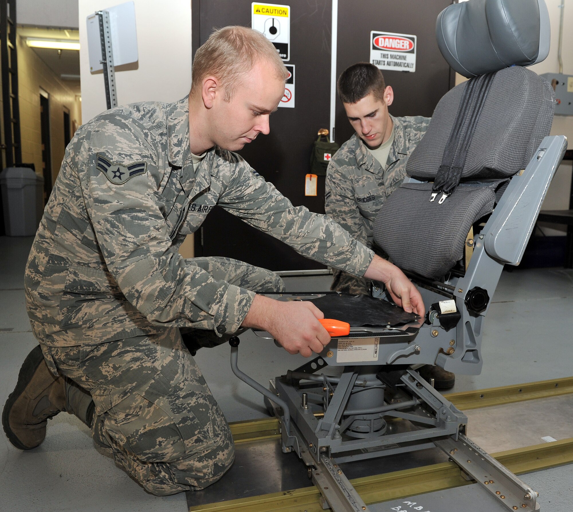 Airmen 1st Class Joseph Hall and Austin Bridges practice replacing a cracked seat pan on a missile combat crew operator’s chair Oct. 31, 2014, in their new Survivable Systems Team work center at Malstrom Air Force Base, Mont. Before SST was formed, repairs at launch control centers were scheduled around maintenance tasks at launch facilities and often considered low priority jobs. The SST is a new team created through Air Force Global Strike Command’s Force Improvement Program to focus primarily on LCC maintenance. Hall and Bridges are 341st Maintenance Group SST members. (U.S. Air Force photo/John Turner)