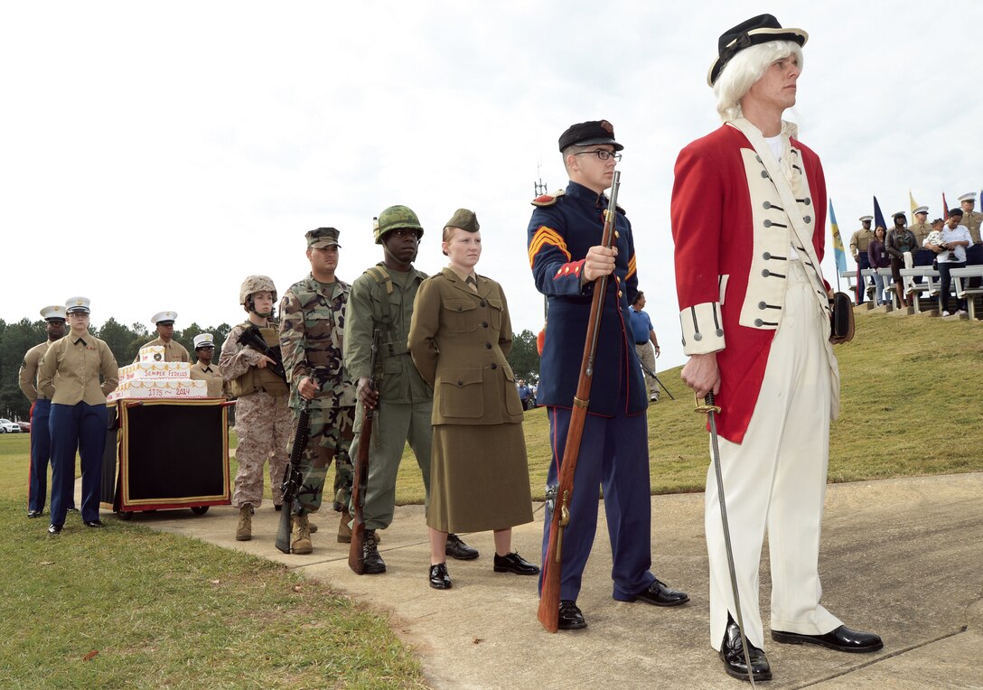 Marines, dressed in uniforms representing different time periods, escort a birthday cake during a celebration recognizing the Marines 239th birthday held at Covella Pond Nov 5.