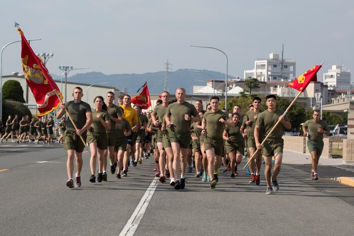 Service members with Marine Aircraft Group 12 run the 239th mile of their Marine Corps Birthday Run, Nov. 7, 2014, aboard Marine Corps Air Station Iwakuni, Japan. Throughout the week, service members took turns running a mile on the seawall with the MAG-12 guideon.