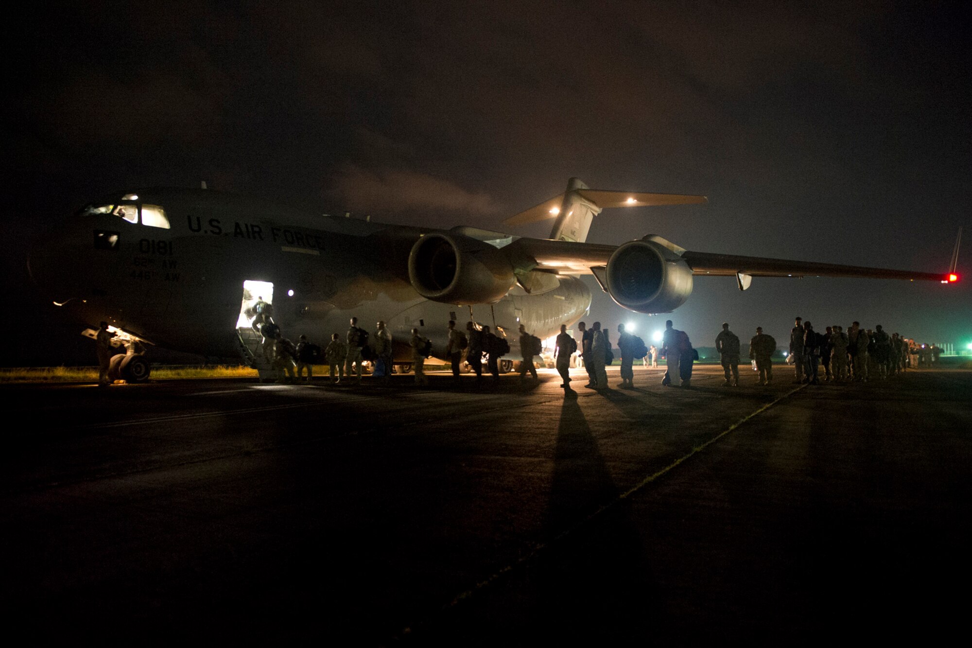 Members of the U.S. Air Force, Army, Navy and Marines board a U.S. Air Force C-17 Globemaster III at Roberts International Airport, Republic of Liberia, during Operation UNITED ASSISTANCE, Nov. 13, 2014. The service members took part in OUA, a Department of Defense operation in Liberia to provide logistics, training and engineering support to U.S. Agency for International Development-led efforts to contain the Ebola virus outbreak in western Africa. (U.S. Air Force photo/Staff Sgt. Gustavo Gonzalez/RELEASED)