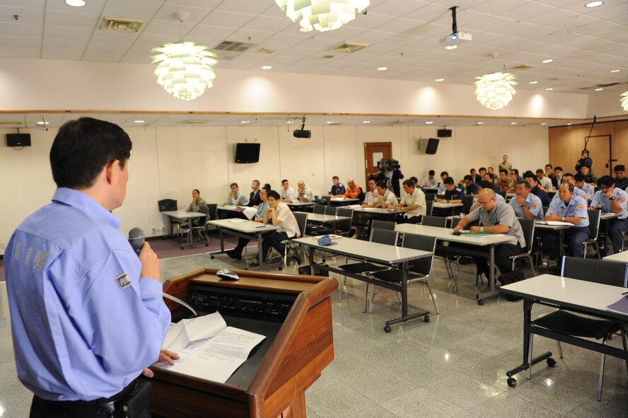 Hidehiko Fujino, cabinet secretariat and director for crisis management in Okinawa, speaks about what would happen in the event of an off base U.S. military aircraft accident in Japan during a tabletop exercise on Kadena Air Base, Nov. 13, 2014. The Bilateral Aircraft Mishap Response exercise was held to answer any questions about what to do during the field training exercise scheduled for Feb. 2015. The purpose of the FTX is to meet the intent of the guidelines regarding off base U.S. military aircraft accidents in Japan, which includes conducting a billateral drill periodically in order to review procedures and maintain close coordination between U.S. military and local agencies with regard to on site actions and procedures during an aircraft emergency. (U.S. Air Force photo by Airman 1st Class Stephen G. Eigel/Released)