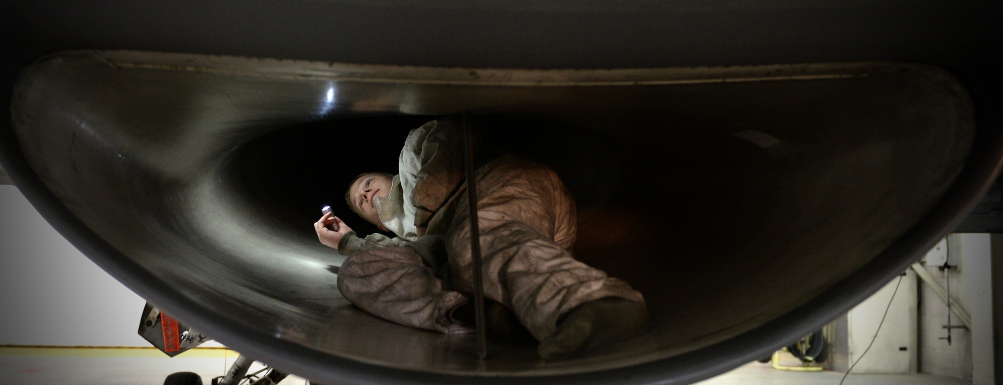 U.S. Air Force Senior Airman Jarrod Decker, a 354th Aircraft Maintenance Squadron engine technician, climbs inside the intake of an F-16 Fighting Falcon fighter aircraft to check for defects prior to an engine test at Eielson Air Force Base, Alaska, Nov. 12, 2014. Maintenance Airmen work on every aspect of the fighter jet from structural to electronic components. (U.S. Air Force photo by Staff Sgt. Shawn Nickel/Released)