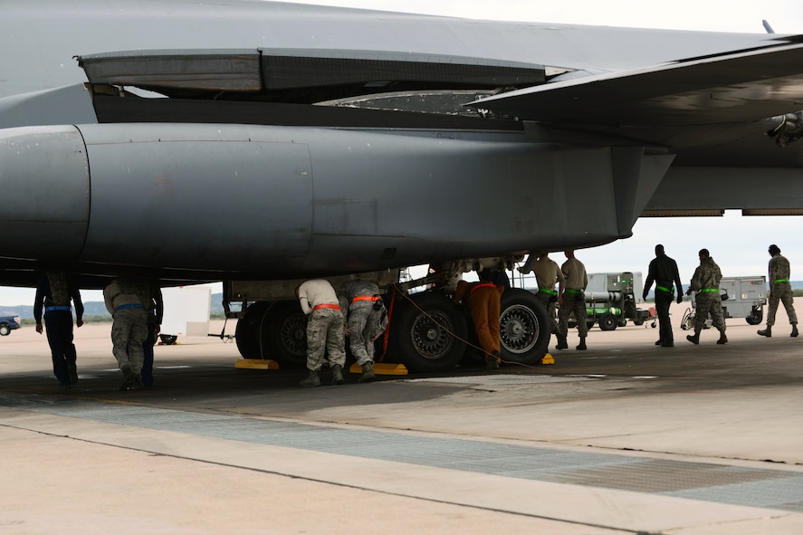 Dyess Airmen from the 7th Maintenance Group conduct a Foreign Object Debris (FOD) walk down the flight line Nov. 5, 2014, at Dyess Air Force Base, Texas. FOD walks are performed to remove debris from areas that aircraft and other flight line equipment operate on. Debris could cause significant damage if it comes in contact with moving mechanical parts. (U.S. Air Force photo by Airman 1st Class Kedesha Pennant/Released)
