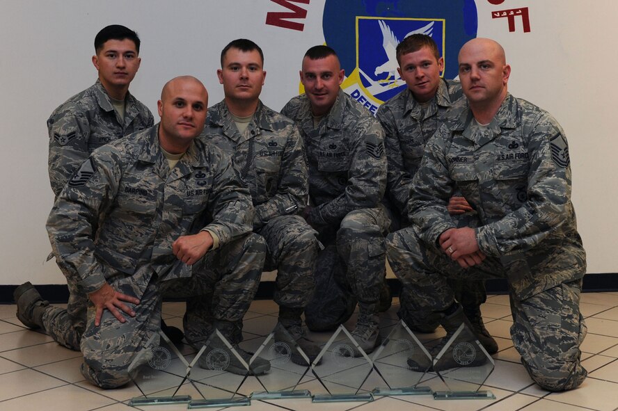 Members of the 28th Security Forces Squadron Global Strike Challenge team pose for a group photo after winning the Security Forces Mental and Physical challenge, Ellsworth Air Force Base, S.D., Nov. 12, 2014. The SF MAP challenge, held during the annual Global Strike Challenge in Guernsey, Wyo., is one of three security forces competitions which tests teams on self-aid and buddy care, memory exercises and a team run. Also during the challenge, the 37th Bomb Squadron achieved the second best bomb score by landing an unguided bomb 25 feet from a target, while the 28th Munitions Squadron won second best bomber maintenance, and participated in a 500 pound guided bomb build competition, attaining the best build time of 57 minutes and nine seconds. (U.S. Air Force photo by Senior Airman Hailey R. Staker/Released) 