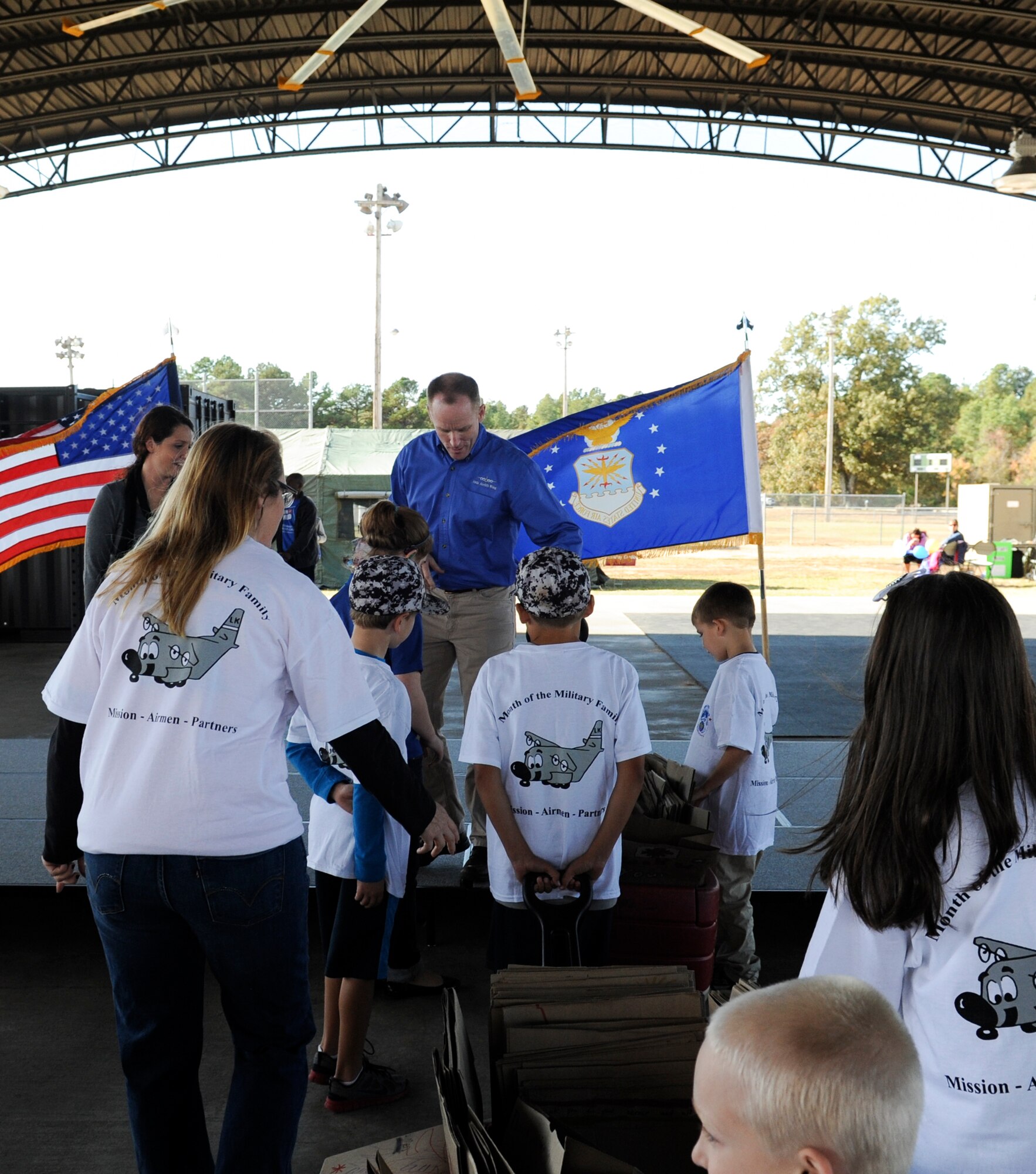 Students from Arnold Drive Elementary School present 500 paper bags decorated by students for a canned food drive to Col. Patrick Rhatigan, 19th Airlift Wing commander, Nov. 8, 2014, at Little Rock Air Force Base, Ark. The presentation was one of the final events during the Month of the Military Family celebration. (U.S. Air Force photo by Staff Sgt. Jessica Condit)