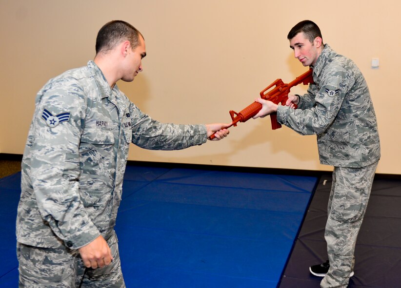Senior Airmen Colton Harvey and Airman 1st Class Charles Simpson, 2nd Security Forces Squadron installation patrolmen, practice disarmament techniques on Barksdale Air Force Base, La., Nov. 6, 2014. Airmen build muscle memory during practice in order to protect themselves and their weapons in the event of a real threat. (U.S. Air Force photo/Airman 1st Class Mozer Da Cunha) 