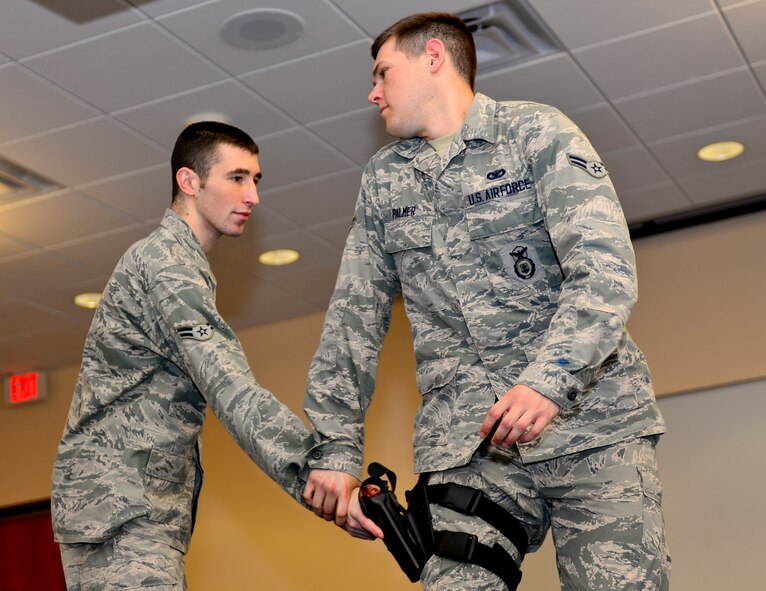 Airmen 1st Class Charles Simpson and Zachary Palmer, 2nd Security Forces Squadron installation patrolmen, practice a pistol disarmamanet scenario on Barksdale Air Force Base, La., Nov. 6, 2014. Airmen practice techniques to protect themselves and their weapons in the line of duty. (U.S. Air Force photo/Airman 1st Class Mozer  Da Cunha)