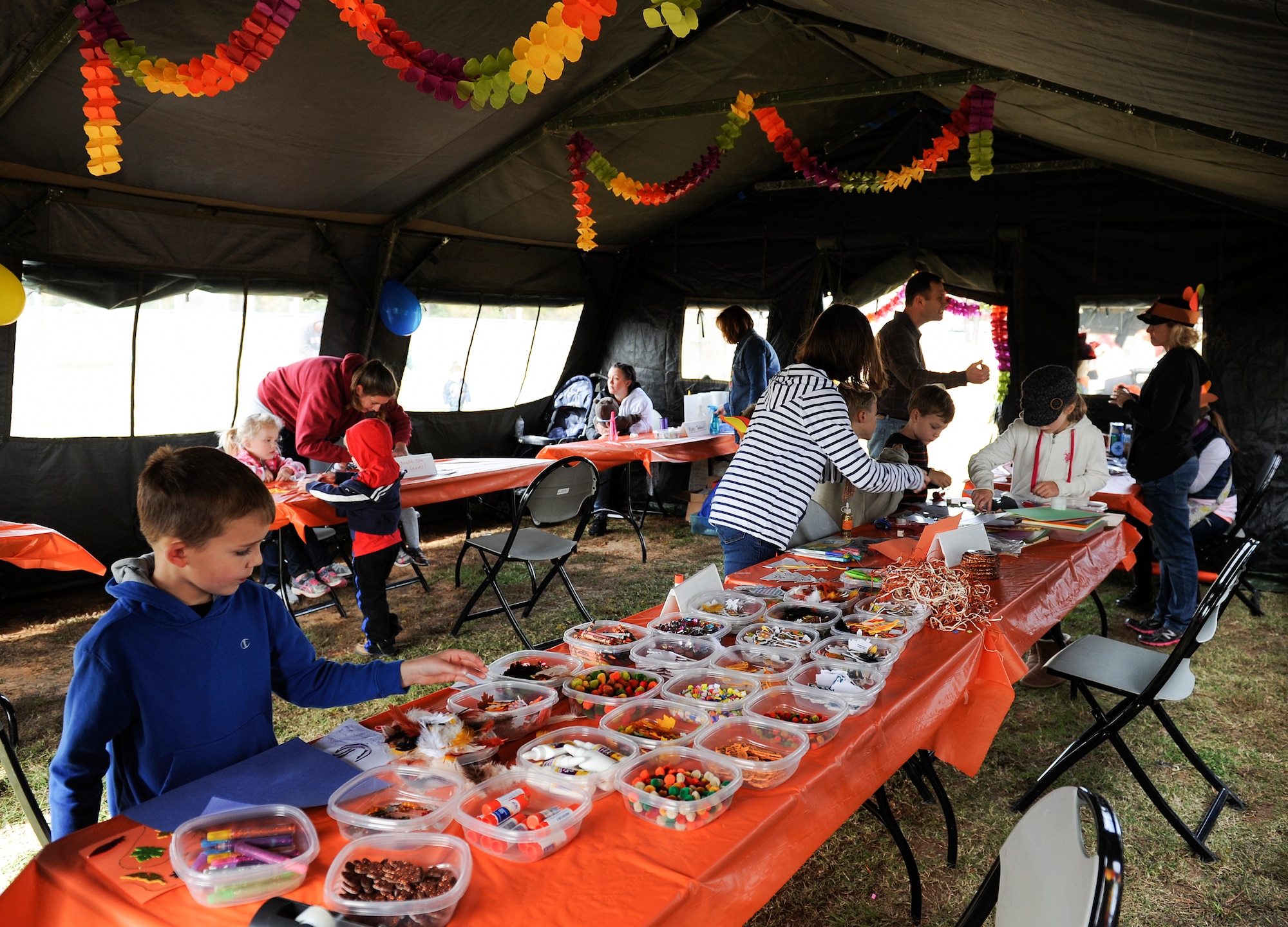 Children make crafts in the craft tent during the Month of the Military Family event Nov. 8, 2014, at Little Rock Air Force Base, Ark. Crafts and games were some of the activities that were available to children during the event. (U.S. Air Force photo by Staff Sgt. Jessica Condit)