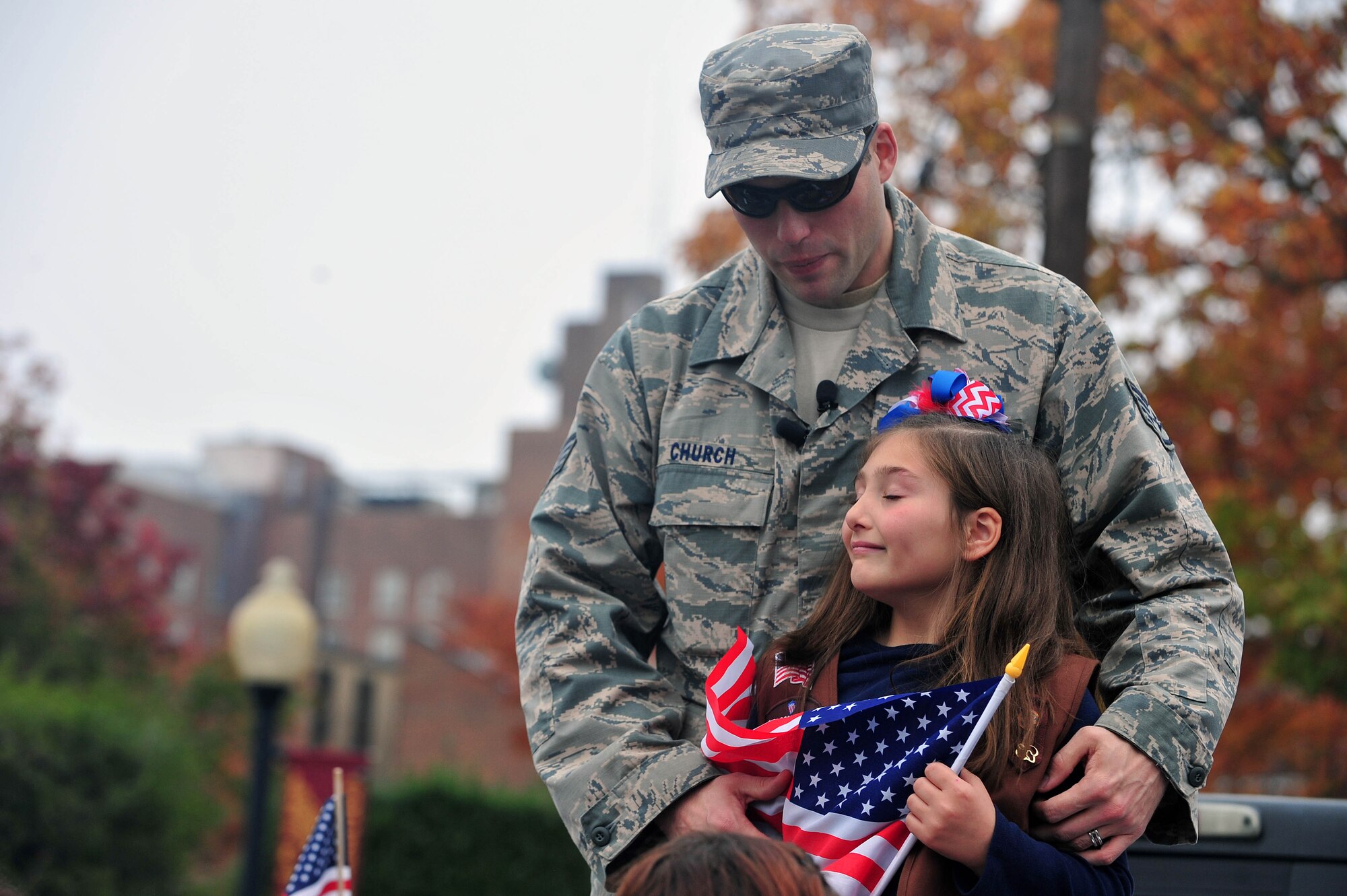 Staff Sgt. Robert Church, 8th Aircraft Maintenance Squadron, Kunsan Air Base, Republic of Korea, reunites with his daughter during the Veterans Day Parade in Goldsboro, North Carolina, Nov. 11, 2014. During the parade, Church came from behind the reviewing stand to surprise his daughter he hasn’t seen in eight months. (U.S. Air Force photo/Senior Airman John Nieves Camacho)