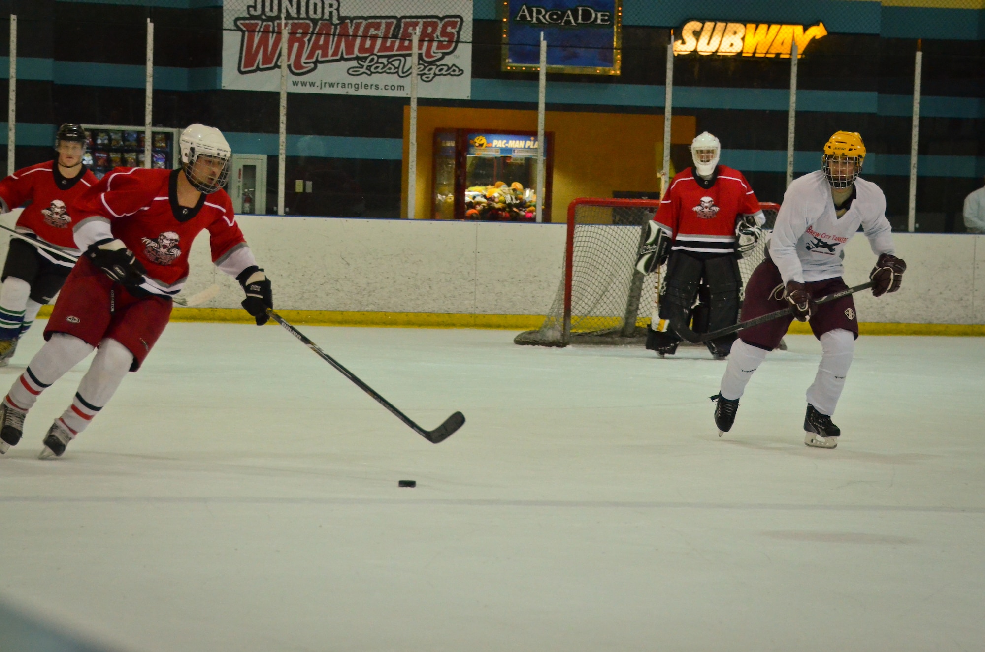 Hockey players with the Badger Militia, a team representing the 115th Fighter Wing and Wisconsin Joint Force Headquarters, maneuver the puck toward the Brew City Tankers, a team representing the 128th Air Refueling Wing, at the 2014 Armed Services Hockey Tournament at the Sobe Ice Arena in Las Vegas Nov. 8, 2014.  (U.S. Air National Guard photo by Staff Sgt. Jenna V. Lenski/Released)