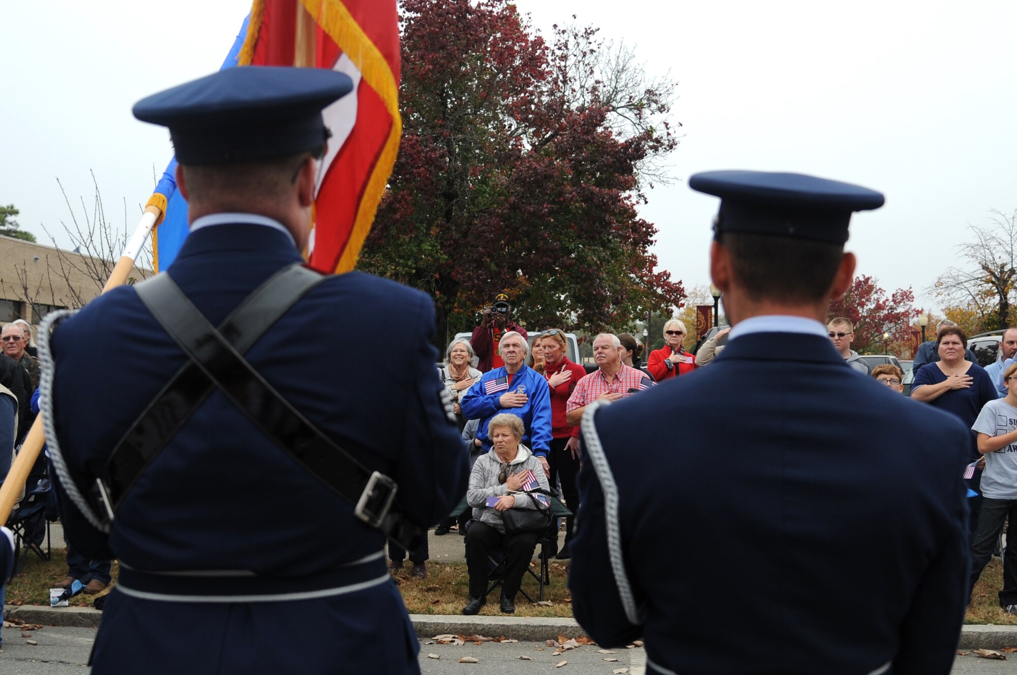 Local residents pay respect to the American flag as members of the 4th Fighter Wing Honor Guard present the colors at the Veterans Day parade in Goldsboro, North Carolina, Nov. 11, 2014. (U.S. Air Force photo/Senior Airman Ashley J. Thum)