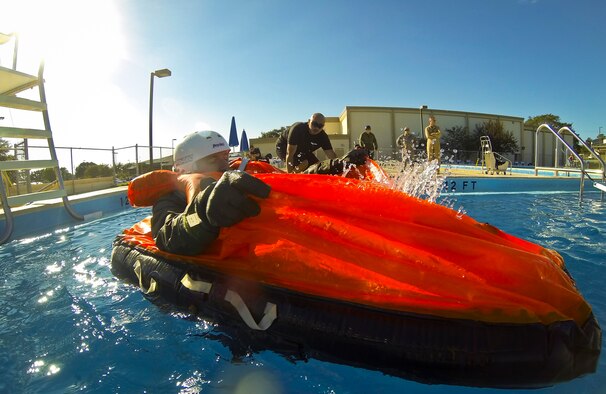 Lt. Col. Ben Aronhime, 56th Training Squadron pilot, removes access water from his life raft as Staff Sgt. Edwin Portan, 33rd Operations Support Squadron F-35 Lightning II aircrew flight equipment continuation training instructor, observes during evaluations at a water survival class on Eglin Air Force Base, Fla., Oct. 31, 2014. Pilots attending F-35 water survival training are placed in simulated scenarios to provide them with the knowledge they need if they were to eject over water.  The 33rd Operations Support Squadron F-35 Lightning II aircrew flight equipment shop incorporated some training elements from previous water survival training programs and developed training tools and techniques to account for the new equipment unique to the F-35 program. (U.S. Air Force photo/Staff Sgt. Marleah Robertson)