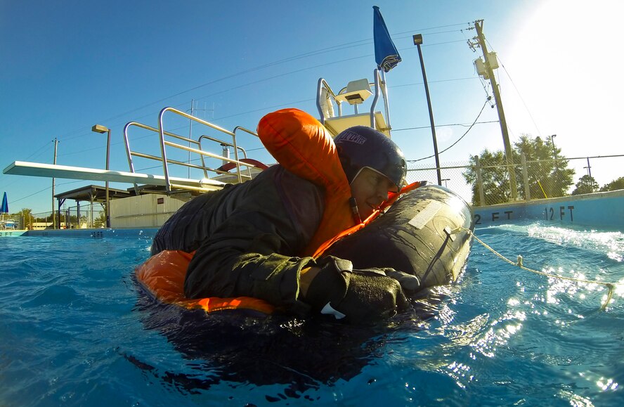 Maj. Brian Hellesto, 357th Fighter Squadron pilot, climbs into a life raft during evaluations at a water survival class on Eglin Air Force Base, Fla., Oct. 31, 2014. Pilots attending F-35 water survival training are placed in simulated scenarios to provide them with the knowledge they need if they were to eject over water.  The 33rd Operations Support Squadron F-35 Lightning II aircrew flight equipment shop incorporated some training elements from previous water survival training programs and developed training tools and techniques to account for the new equipment unique to the F-35 program. (U.S. Air Force photo/Staff Sgt. Marleah Robertson)