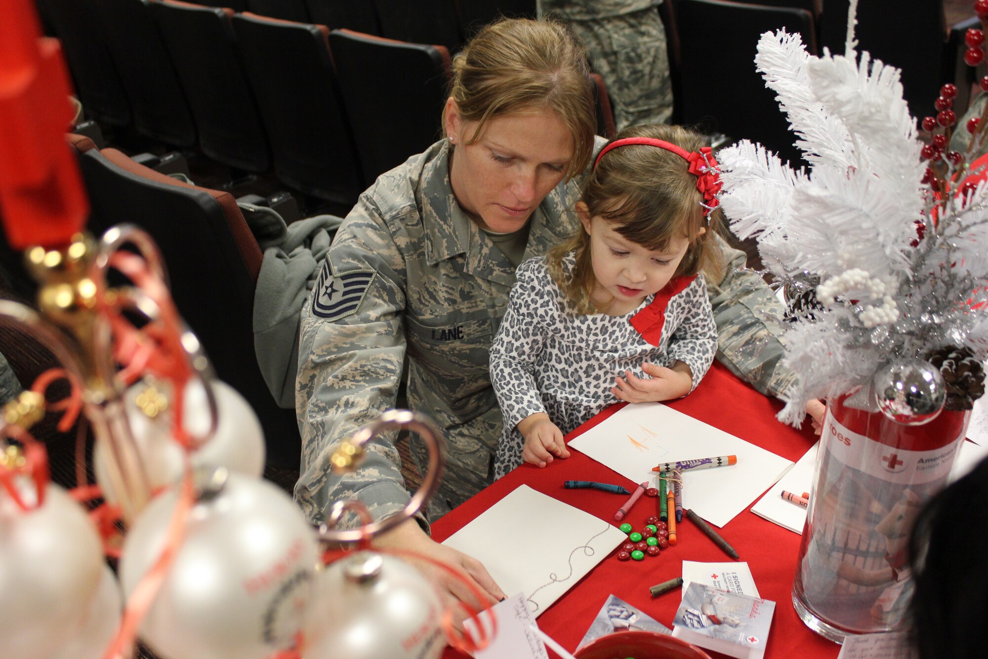 Tech. Sgt. Amy Lane, 916th Air Refueling Wing, and the child of a fellow wing member participate in a previous Holiday Mail event. The 2014 event, held on Nov. 14, will mark the third consecutive year the wing has partnered with the American Red Cross for the program. (photo courtesy of the American Red Cross)