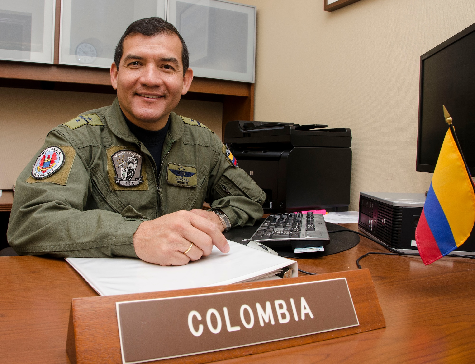 Colonel Carlos Torres, Air Forces Southern Colombian Liaison Officer, smiles before preparing to execute his daily duties as LNO at Davis-Monthan AFB, Ariz., Nov. 5, 2014. Torres has been following in his father’s footsteps and began his Colombian air force career in 1987 and now, as the Colombian air force’s liaison officer for Air Forces Southern, he hopes to raise awareness of the important changes his country has made to become a regional leader in South America. (U.S. Air Force photo by Staff Sgt. Adam Grant/Released) 