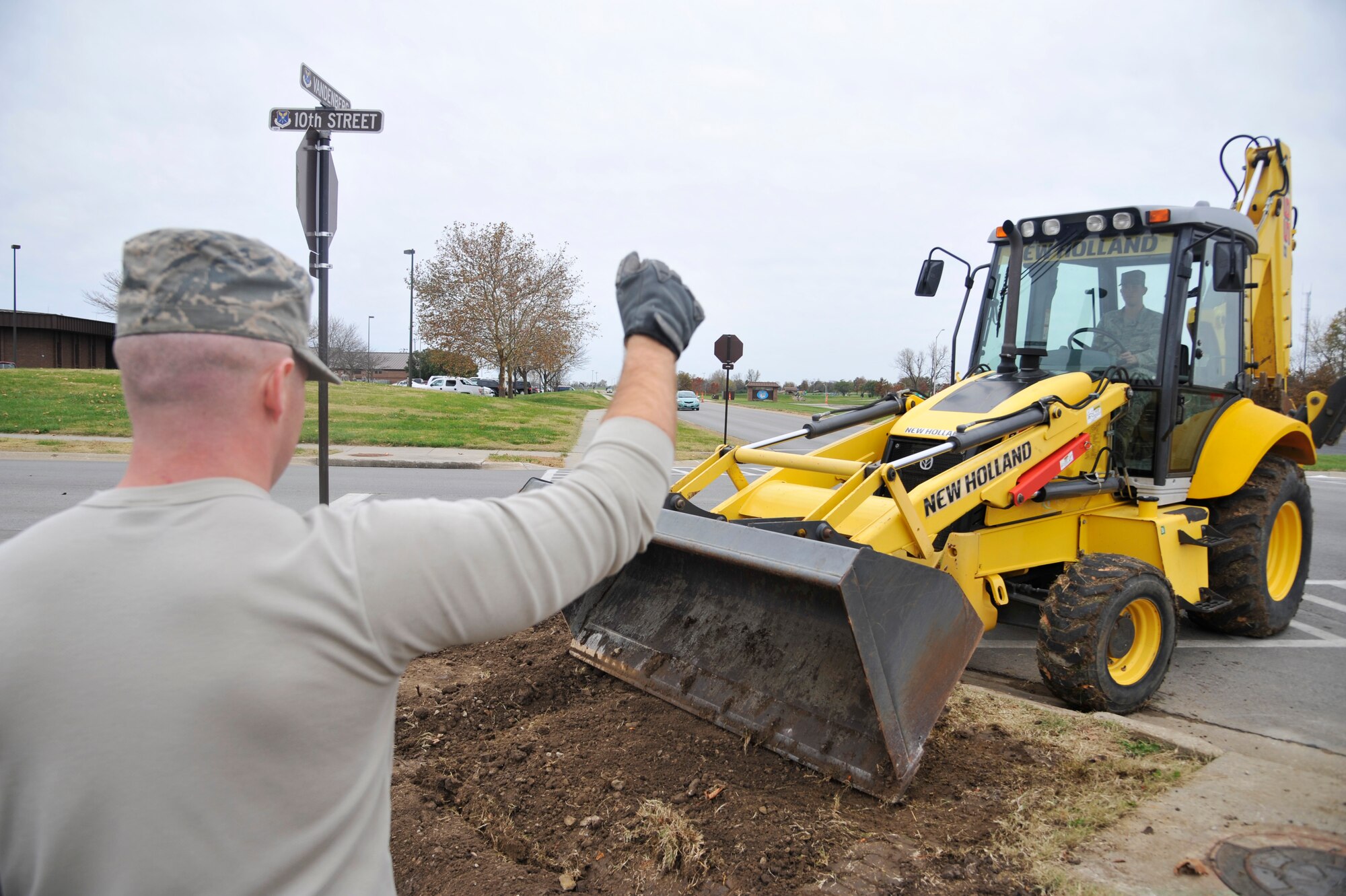 U.S. Air Force Senior Airman Matthew Nipper spots Senior Airman Michael Worton, both Civil Engineer Squadron journeymen, while he operates a backhoe at Whitman Air Force Base, Mo., Nov. 4, 2014. It’s important to have a spotter present when operating equipment to ensure safety. (U.S. Air Force photo by Airman 1st Class Keenan Berry/Released)