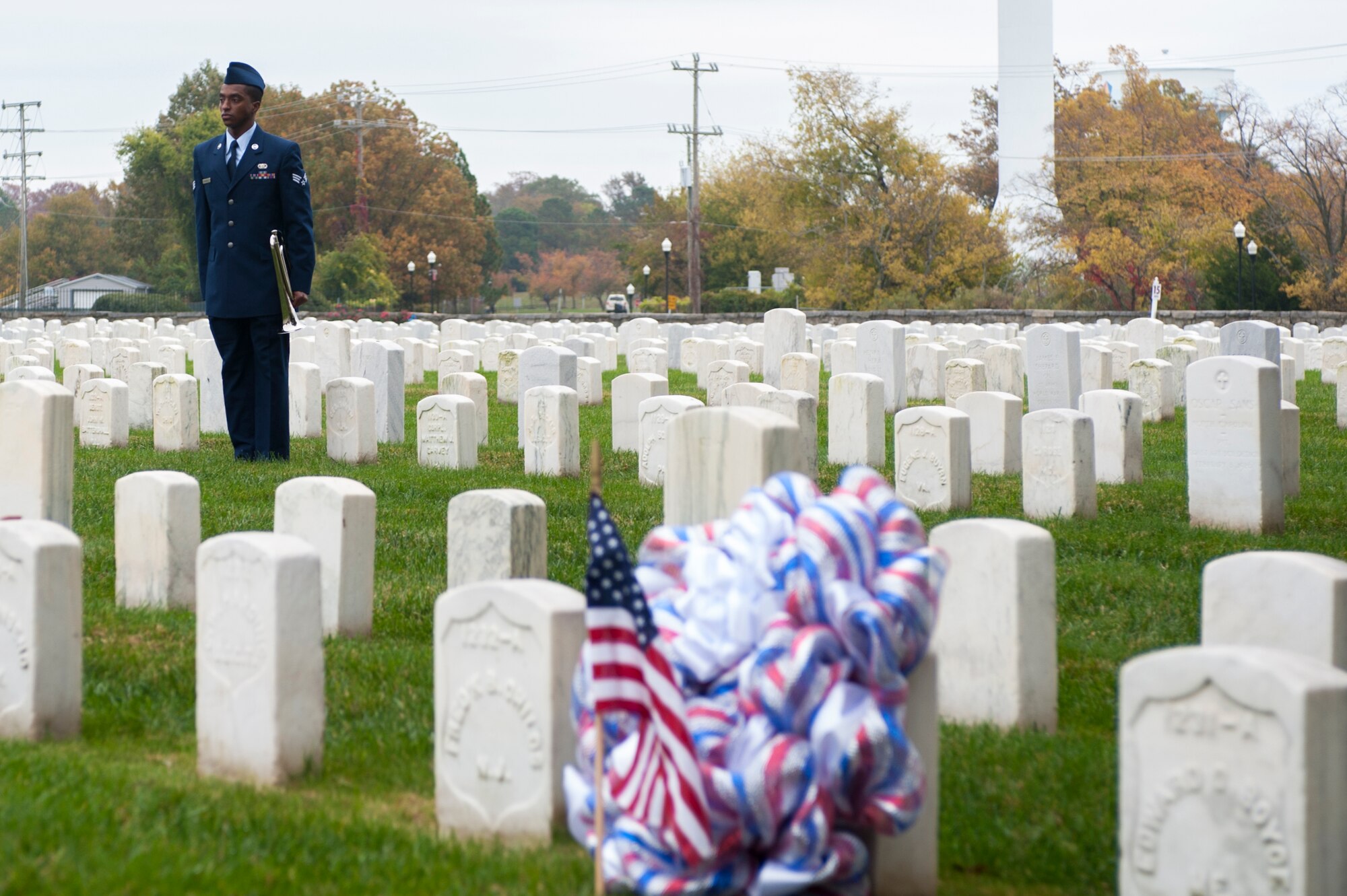 U.S. Air Force Senior Airman Marc Granville, 440th Supply Chain Operations Squadron security systems analyst, stands at attention after playing “Taps” during the Langley African-American Heritage Council Veterans Day wreath-laying ceremony Nov. 11, 2014, at the Hampton National Cemetery in Hampton, Va. The ceremony honored U.S. Army Sgt. Alfred B. Hilton, an African-American service member and Medal of Honor recipient who served in in the Union Army during the Civil War. (U.S. Air Force photo by Senior Airman R. Alex Durbin/Released)