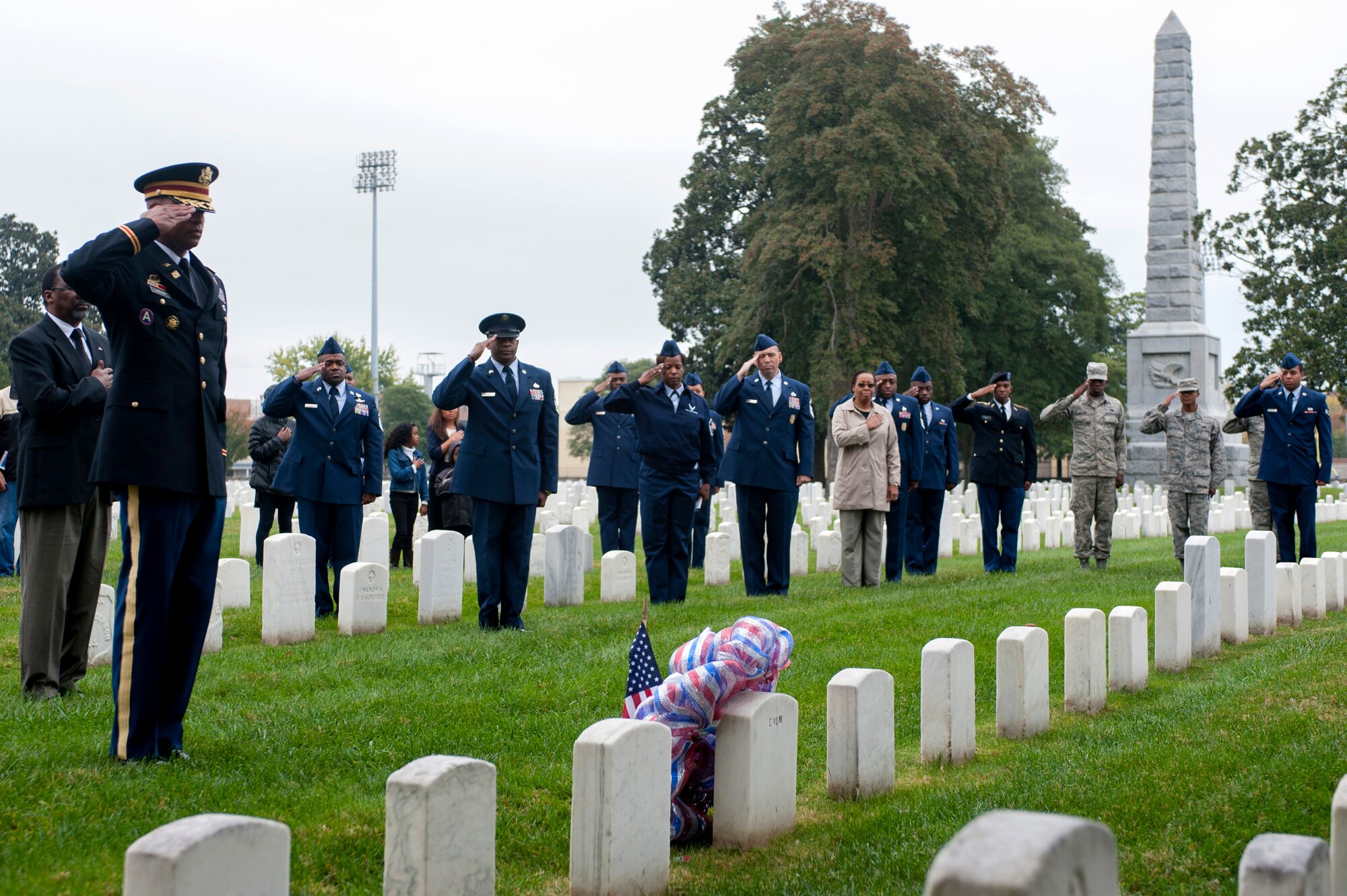 Attendees of the Langley African American Heritage Council Veterans Day wreath-laying ceremony pay respects to U.S. Army Sgt. Alfred B. Hilton, a Civil War-era Medal of Honor recipient Nov. 11, 2014, at the Hampton National Cemetery in Hampton, Va. During the charge of New Market Heights, Hilton distinguished himself in the line of duty when he was injured as flag bearer, but continued forward. (U.S. Air Force photo by Senior Airman R. Alex Durbin/Released)
