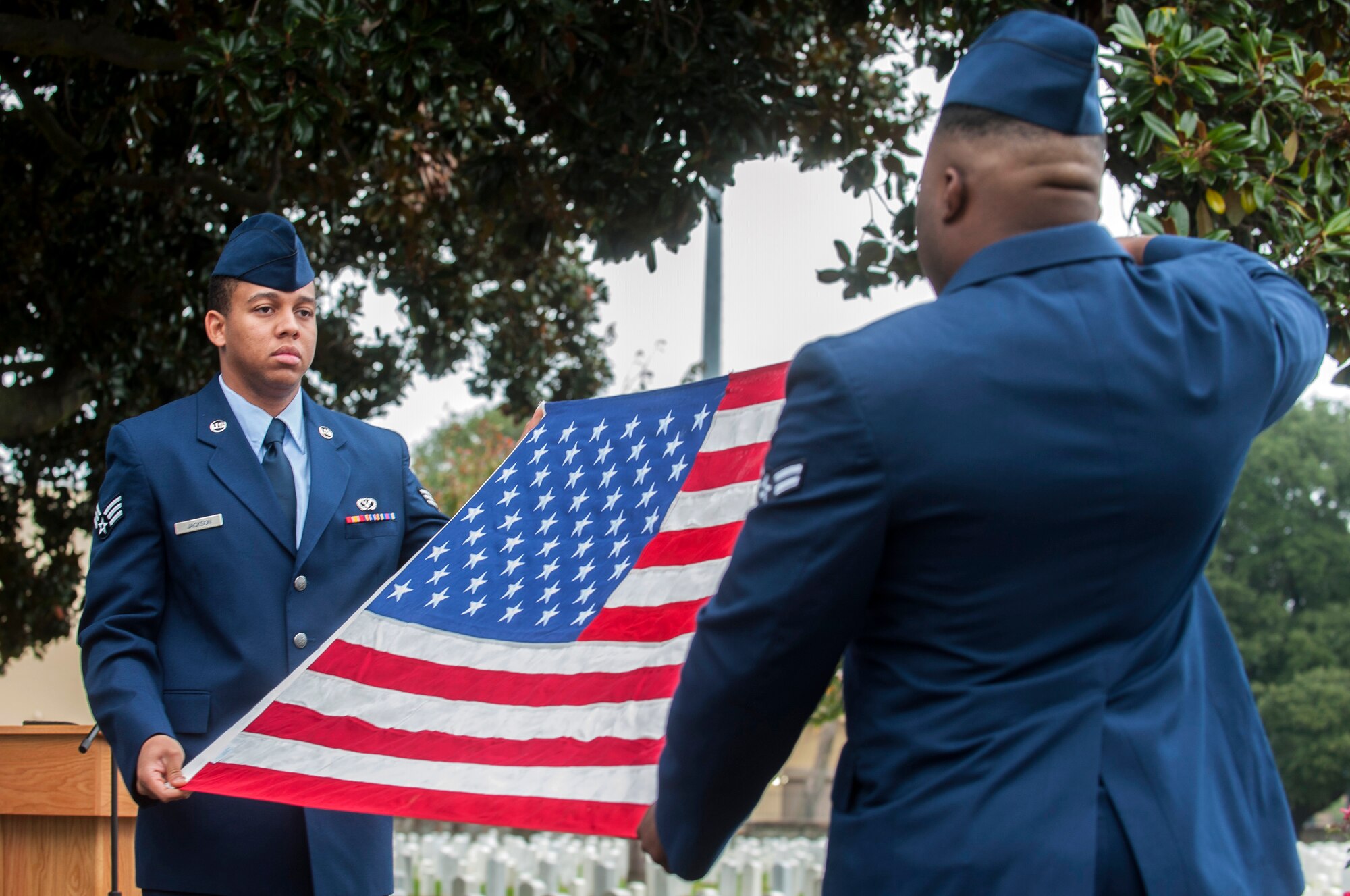 U.S. Air Force Senior Airman Jerald Jackson, 633rd Civil Engineer Squadron engineer technician, and Airman 1st Class Kevin Bass, 1st Maintenance Squadron equipment maintenance technician, provide flag-folding services during the Langley African-American Heritage Council Veterans Day wreath-laying ceremony Nov. 11, 2014, at the Hampton National Cemetery in Hampton, Va. The ceremony was held in honor of all U.S. military veterans and U.S. Army Sgt. Alfred B. Hilton, who earned the Medal of Honor at the battle of New Market Heights in 1864. (U.S. Air Force photo by Senior Airman R. Alex Durbin/Released)