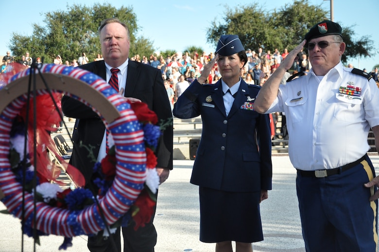 Brig. Gen. Nina Armagno, 45th Space Wing commander, is joined by (left) Dr. Jim Richey, Eastern Florida State College president, and (right) retired Army Lt. Col. Henry Adams, during the wreath presentation at the 32nd Annual Massing of the Colors Veterans Day event held Nov. 11, 2014, at the George F. Schlatter Veterans Memorial Amphitheater at the Cocoa Campus of Eastern Florida State College in Cocoa, Fla. (U.S. Air Force photo/Christopher Calkins)