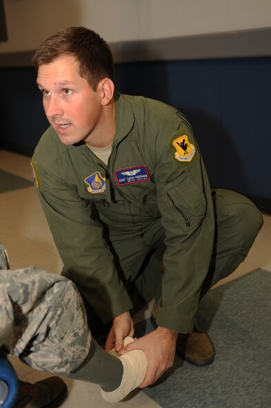 U.S. Air Force Staff Sgt. Zachary Freeman, 18th Aeromedical Evacuation Squadron aeromedical evacuation technician, bandages a simulated patient's foot during an exercise in support of Keen Sword on Kadena Air Base, Japan, Nov. 12, 2014. Keen Sword allows the U.S. and Japan to practice coordination procedures and improve interoperability required to effectively defend Japan or respond to crises throughout the Asia-Pacific region. (U.S. Air Force photo by Airman 1st Class Zade C. Vadnais/Released)