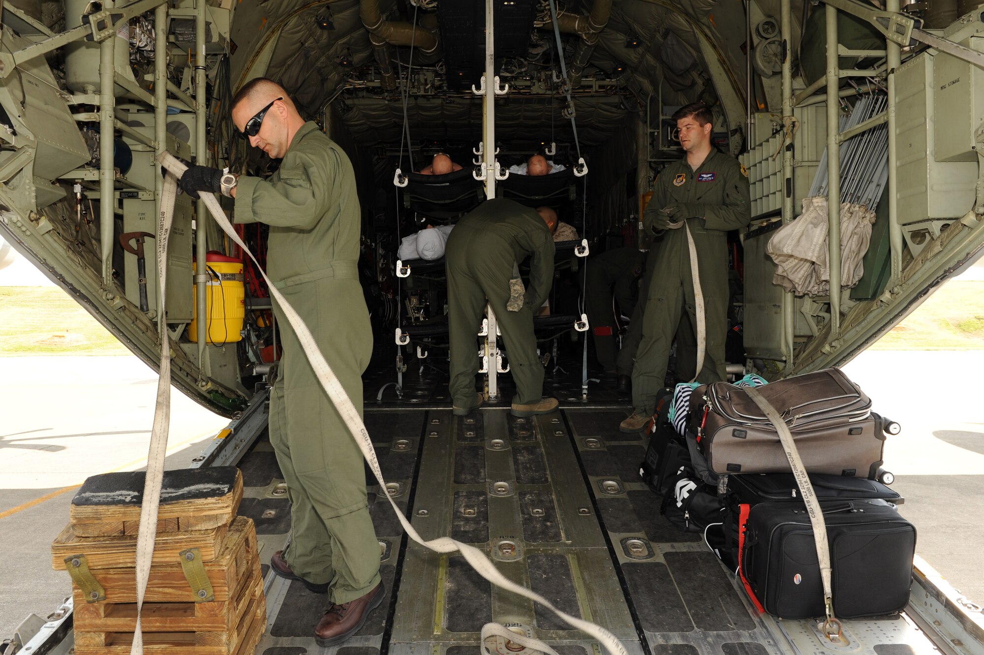U.S. Airmen and Marines secure cargo on a Marine Corps C-130 before takeoff during an exercise in support of Keen Sword on Kadena Air Base, Japan, Nov. 12, 2014. Exercises such as Keen Sword provide the 33rd Rescue Squadron effective and intense training to ensure our forces are capable, interoperable and deployable on short notice and combat-ready. (U.S. Air Force photo by Airman 1st Class Zade C. Vadnais/Released)