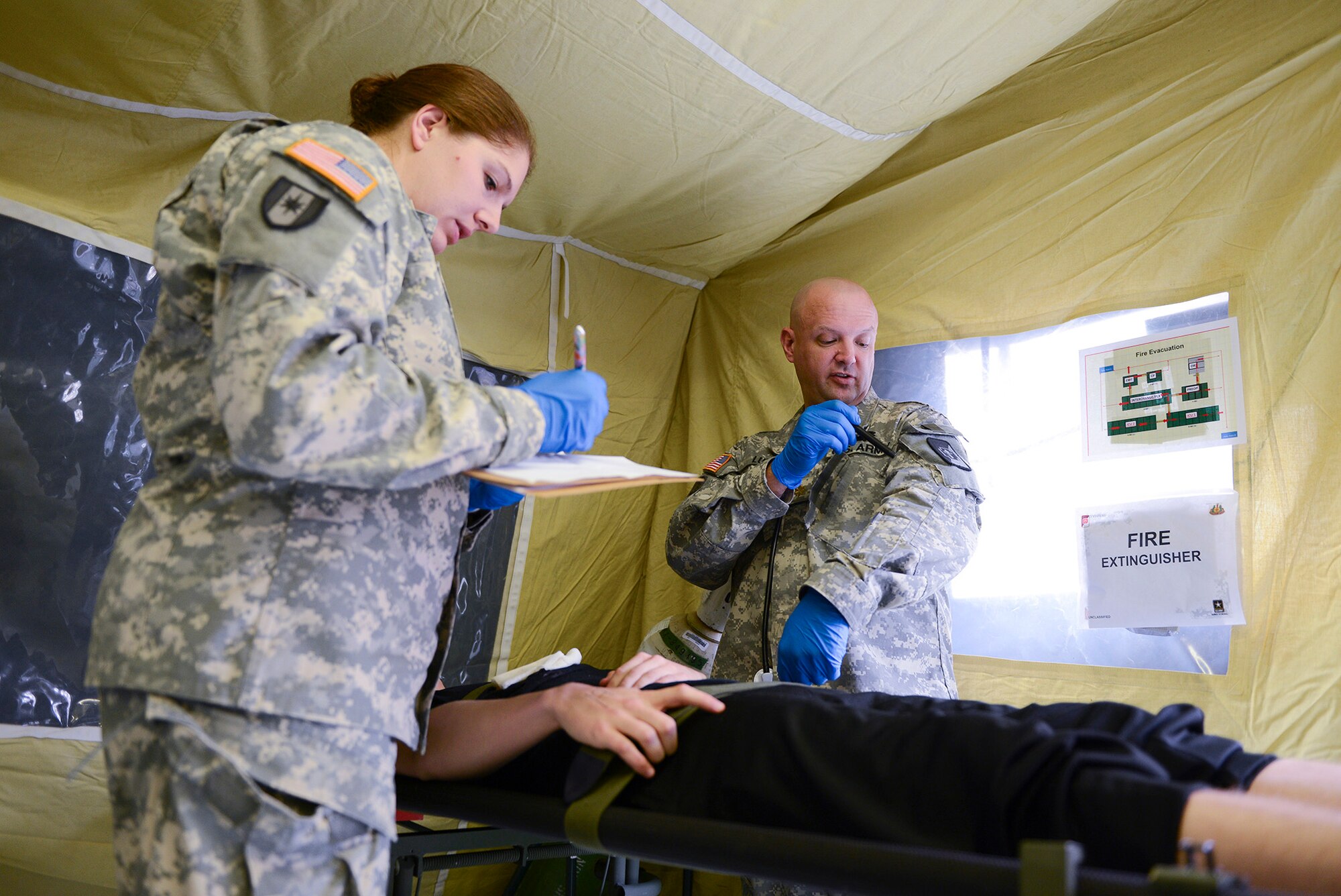 U.S. Army Maj. Keith Lund and Capt. Regina Thorp inspect a patient just received from a C-130 Hercules during medical evacuation training at Yokota Air Base, Japan, Nov. 12, 2014. Lund and Thorp are with the 47 Combat Support Hospital out of Joint Base Lewis-McChord, Washington. The training was part of Keen Sword 2015, a joint and bilateral exercise aimed at improving military readiness and strengthening the Japanese-U.S. alliance. (U.S. Air Force photo by Staff Sgt. Cody H. Ramirez/Released)