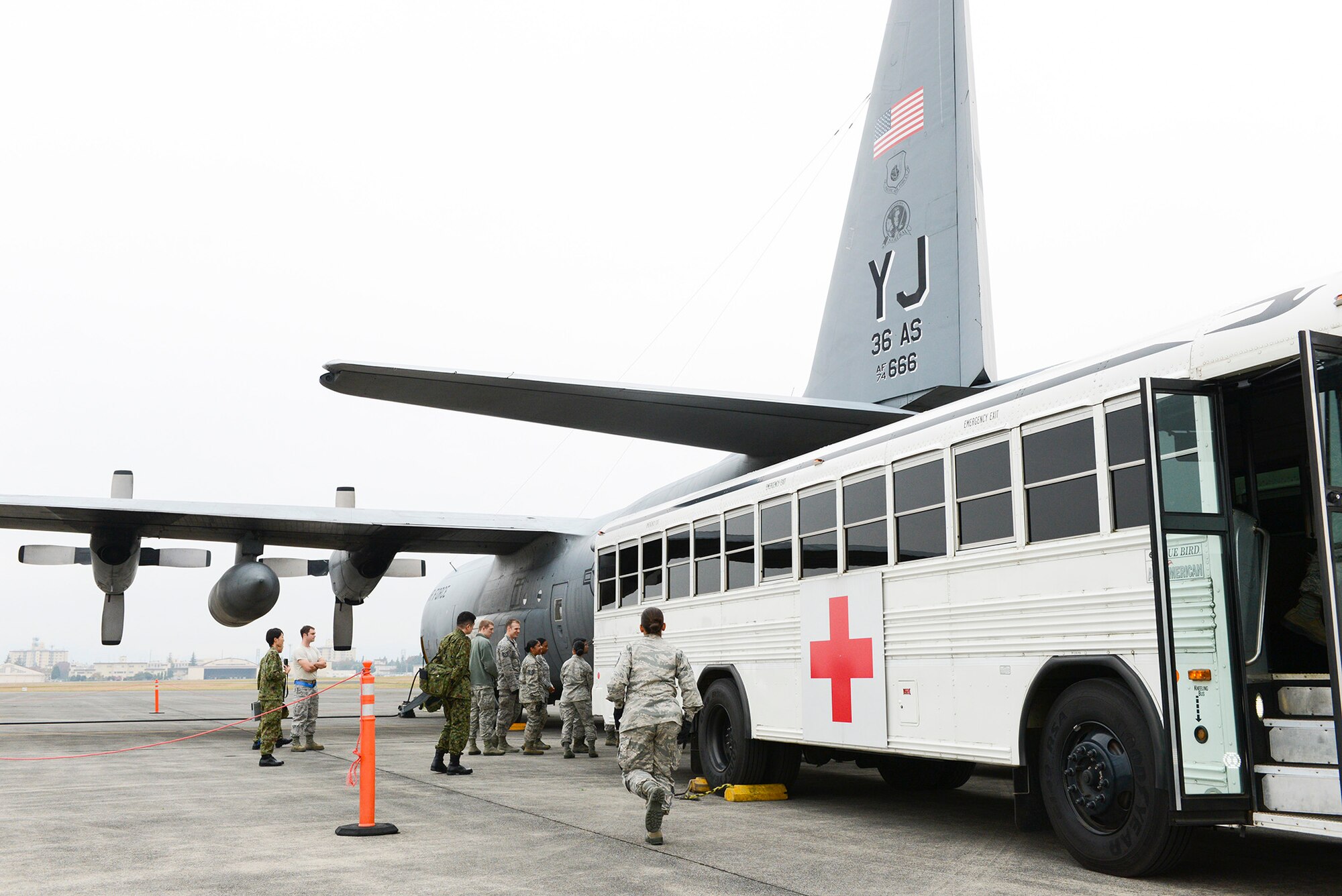Exercise patients are carried to transport buses from a C-130 Hercules during medical evacuation training for Exercise Keen Sword 2015 at Yokota Air Base, Japan, Nov. 12, 2014. Yokota develops medical evacuation support capabilities by utilizing the three aircraft stationed at the Air Force base – C-130s, UH-1N Hueys and C-12 Hurons. (U.S. Air Force photo by Staff Sgt. Cody H. Ramirez/Released)