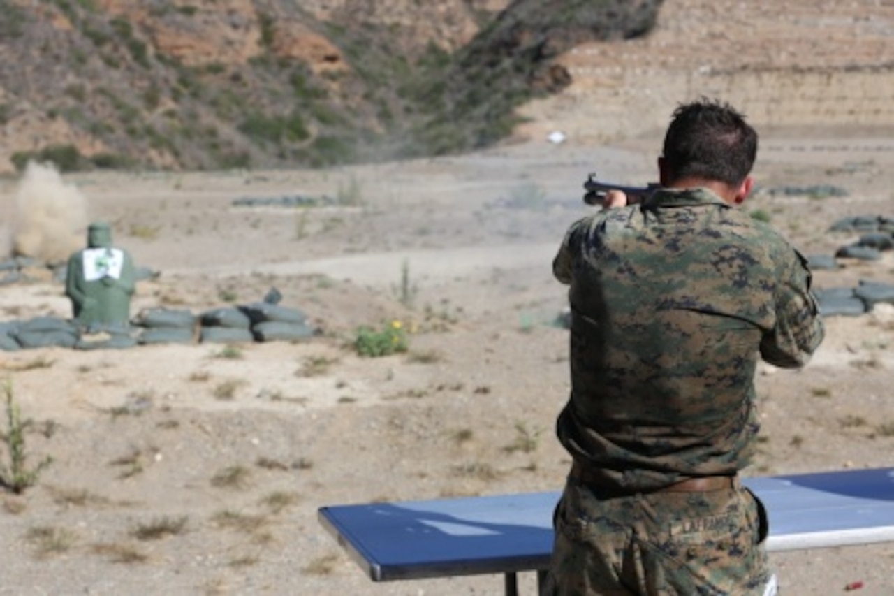 Marine Corps Cpl. James Lafrance, with Force Company, 1st Reconnaissance Battalion, 1st Marine Division, shoots targets with a shotgun during a physical training exercise at Marine Corps Base Camp Pendleton, Calif., Nov. 7, 2014. The exercise included an eight-mile hike with multiple events along the route to test the Marines’ proficiency with various weapon systems. U.S. Marine Corps photo by Cpl. Joshua Murray