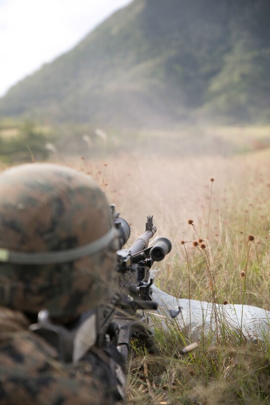 A U.S. Marine fires an M240B medium machine gun while participating in exercise Blue Chromite 15 on the Central Training Area in Okinawa, Japan, Nov. 2, 2014. 