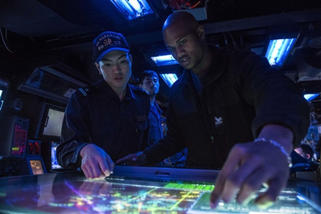 U.S. Navy Petty Officer 2nd Class Keith Reeves, right, monitors a console in the ship’s combat information center, with Japan Maritime Self-Defense Force Lt. j.g. Kotaro Kitahara, during Exercise Keen Sword 2015 at sea, Nov. 12, 2014. 