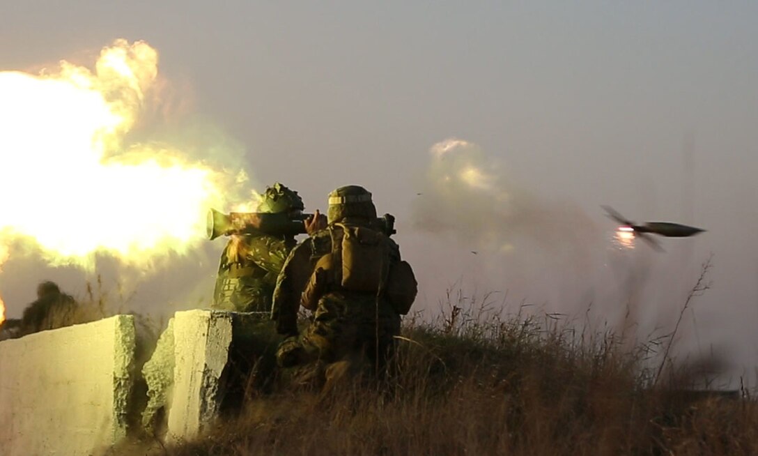 A Romanian soldier fires an AT4 at a target with Marine from Black Sea Rotational Force 14 during Platinum Lynx 15. Marines and Sailors worked hand-in-hand with Romanian Land Forces during exercise Platinum Lynx 15 in Focsani, Romania. (U.S. Marine Corps photo by Lance Cpl. Ryan Young/released)