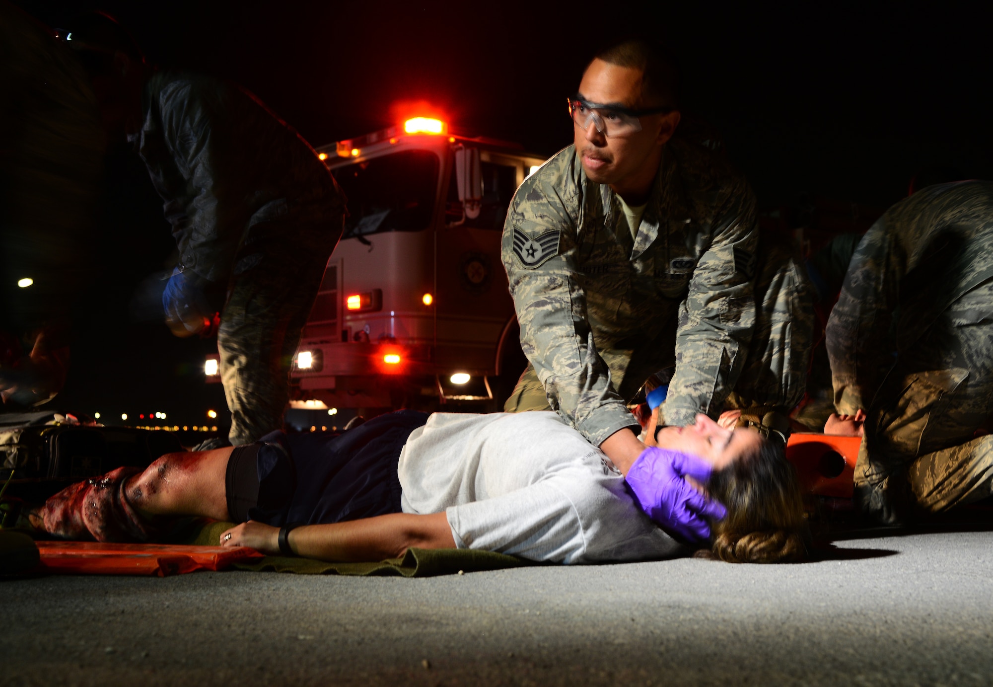 First responders tend to simulated victims of a vehicle accident during a mass casualty exercise Nov. 10, 2014, at Al Udeid Air Base, Qatar. Airmen from the 379th Expeditionary Medical Group and firefighters from the 379th Expeditionary Civil Engineer Squadron responded to the accident scene to assess the patients and transport them to the 379th EMDG for medical treatment. The training provided by these types of exercises keep Airmen ready to respond to real-world scenarios at a moment’s notice. (U.S. Air Force photo by Senior Airman Kia Atkins)