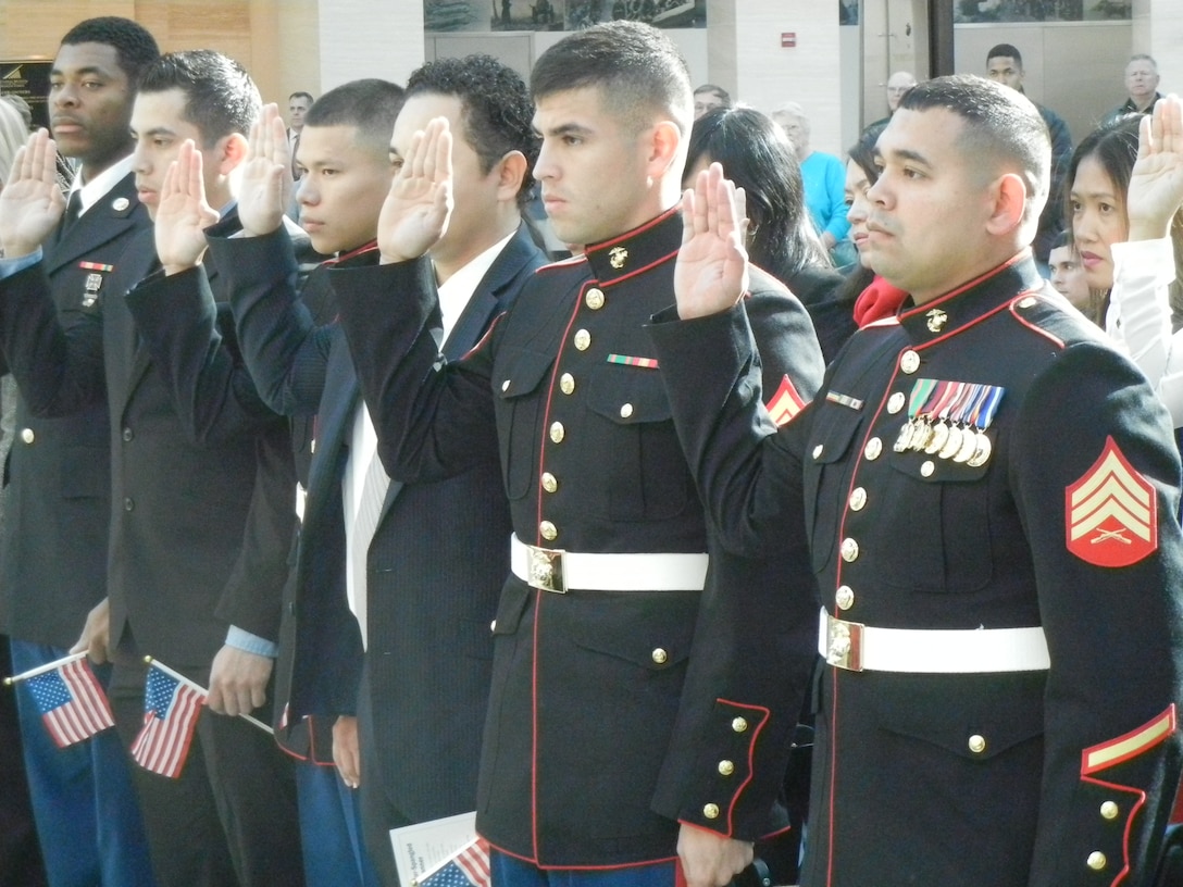 Sgt. Gustavo Antonio Arroliga-Lopez, a Marine recruiter in Woodbridge and a native of Nicaragua, takes the Oath of Allegiance during Monday’s naturalization ceremony at the National Museum of the Marine Corps. Four Marines were among the 26 newest citizens hailing from 20 different countries.