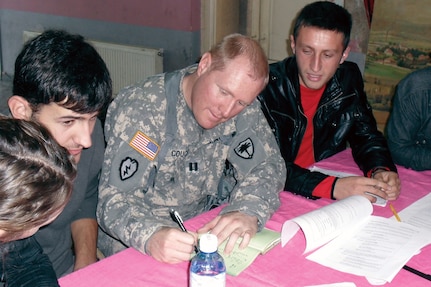 Capt. Jeff M. Couch, of the 2-151st Aviation Battalion of the 
South Carolina National Guard, works with high school students in an English as a Second Language class at the Ferizaj, Kosovo, Youth Center.